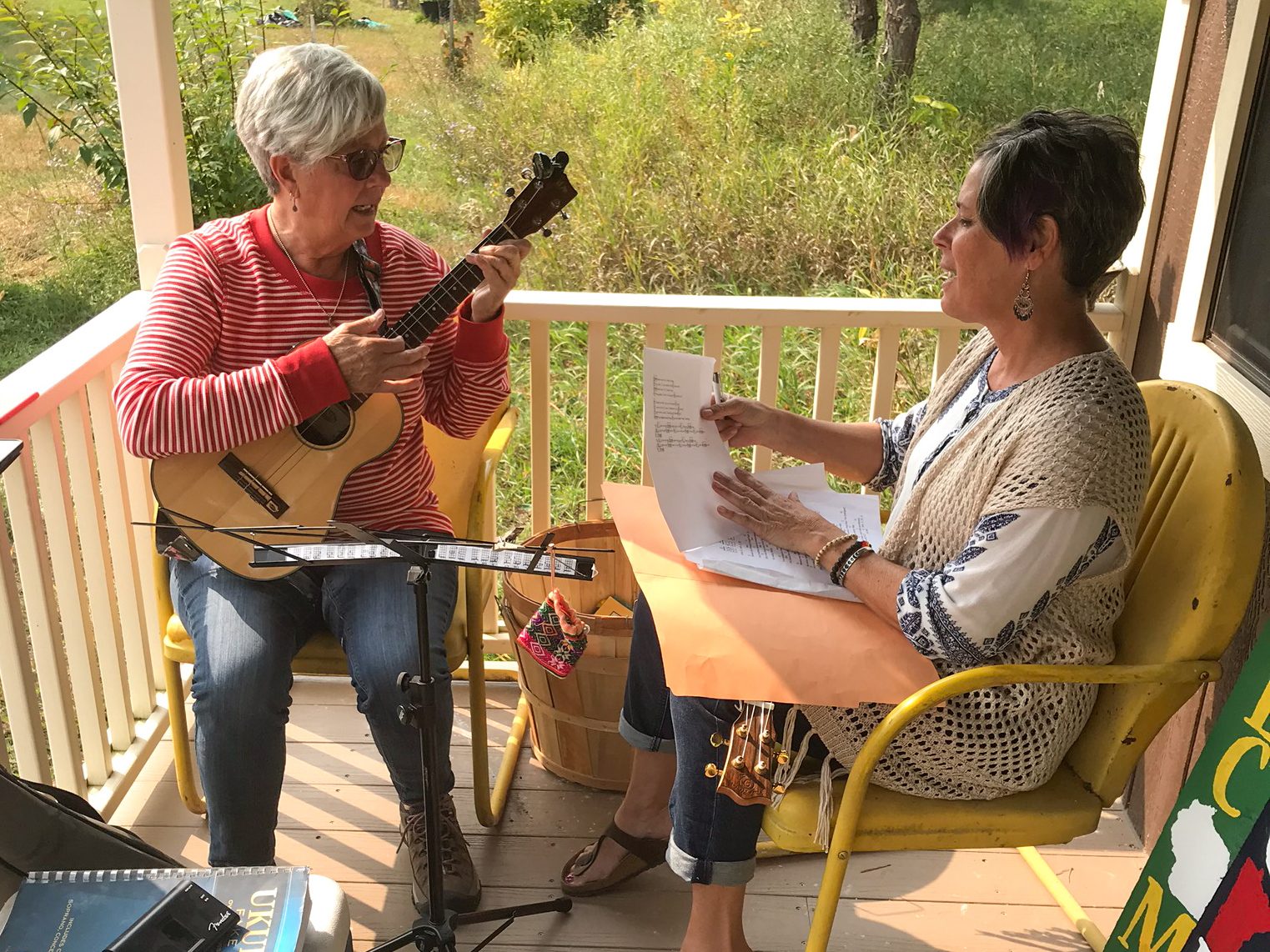 Playing the ukulele on the front porch of the cabin shed retail store